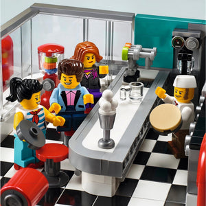 LEGO minifigures in a coffee shop setting with a barista and customers.