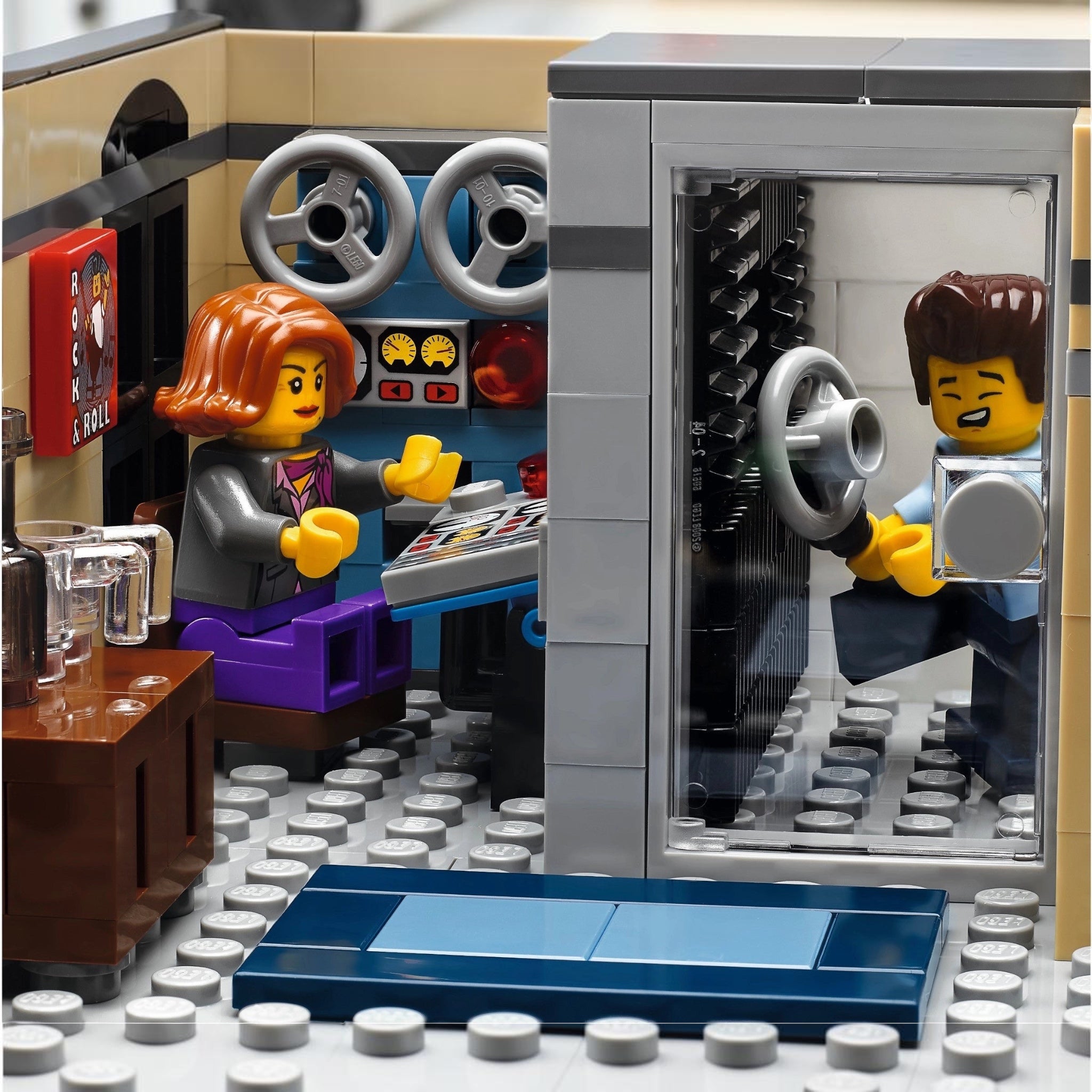 LEGO model of a car interior with two minifigures inside, one driving and one sitting.