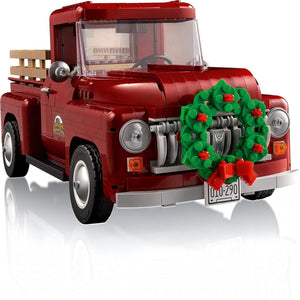 Red toy truck with a Christmas wreath on a white background