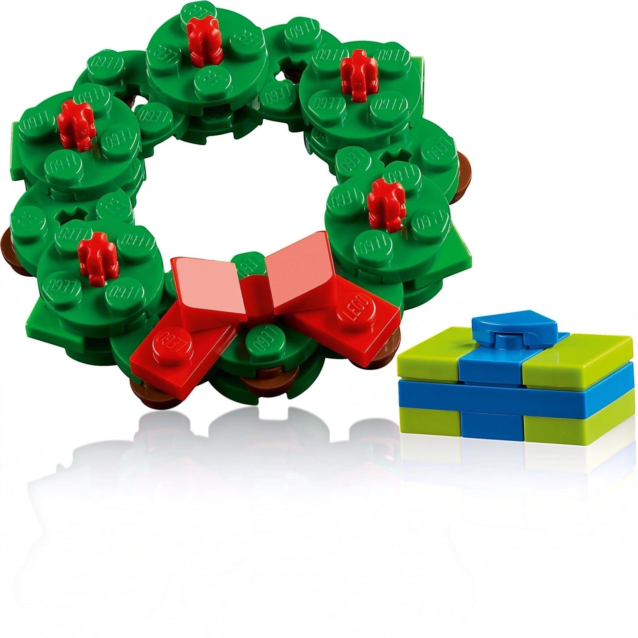 Christmas wreath made of green building blocks with red details and a blue gift box on a white background
