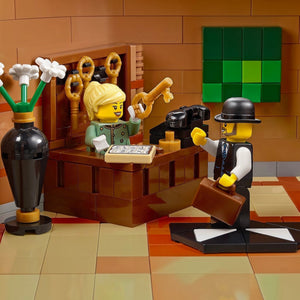 LEGO figures in a scene with a desk and various items on a checkered floor.
