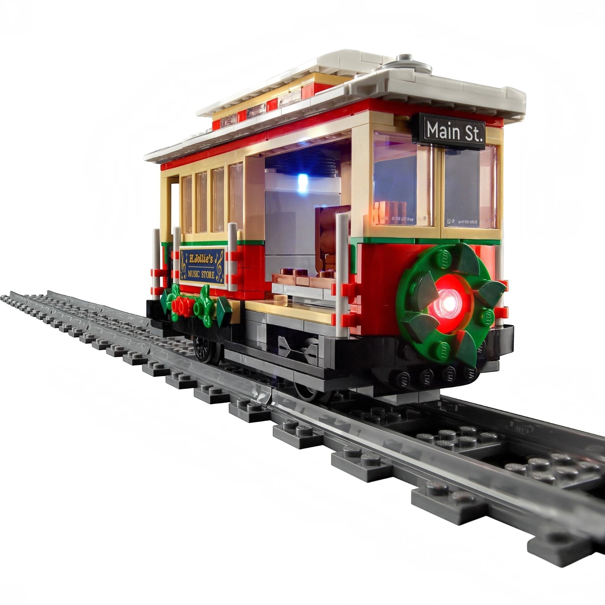 Toy trolley model on tracks with a white background