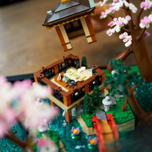 Close-up of a detailed LEGO model with a pagoda, table, and cherry blossoms.