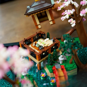 [lifestyle-shelf-built] Close-up of a detailed LEGO model with a pagoda, table, and cherry blossoms.