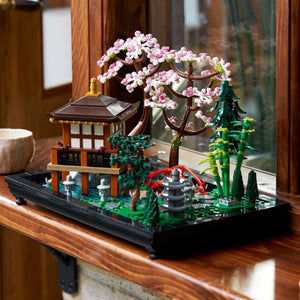 [lifestyle-shelf-built] Model of a Japanese temple with cherry blossom tree and fountain on a wooden surface.