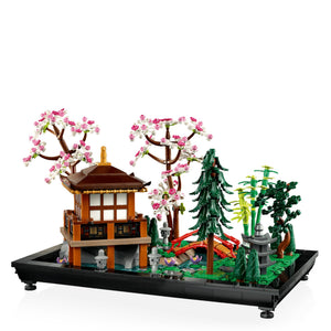 LEGO model of a Japanese-style building with cherry blossom trees and greenery on a white background