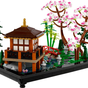 LEGO model of a Japanese-style building with cherry blossom tree and bridge on a transparent background