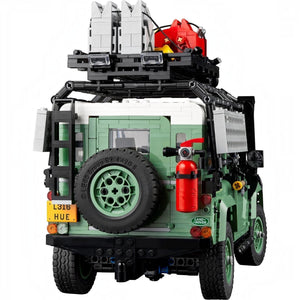 LEGO model of a vehicle with green body, black tires, and red fire extinguisher on a white background