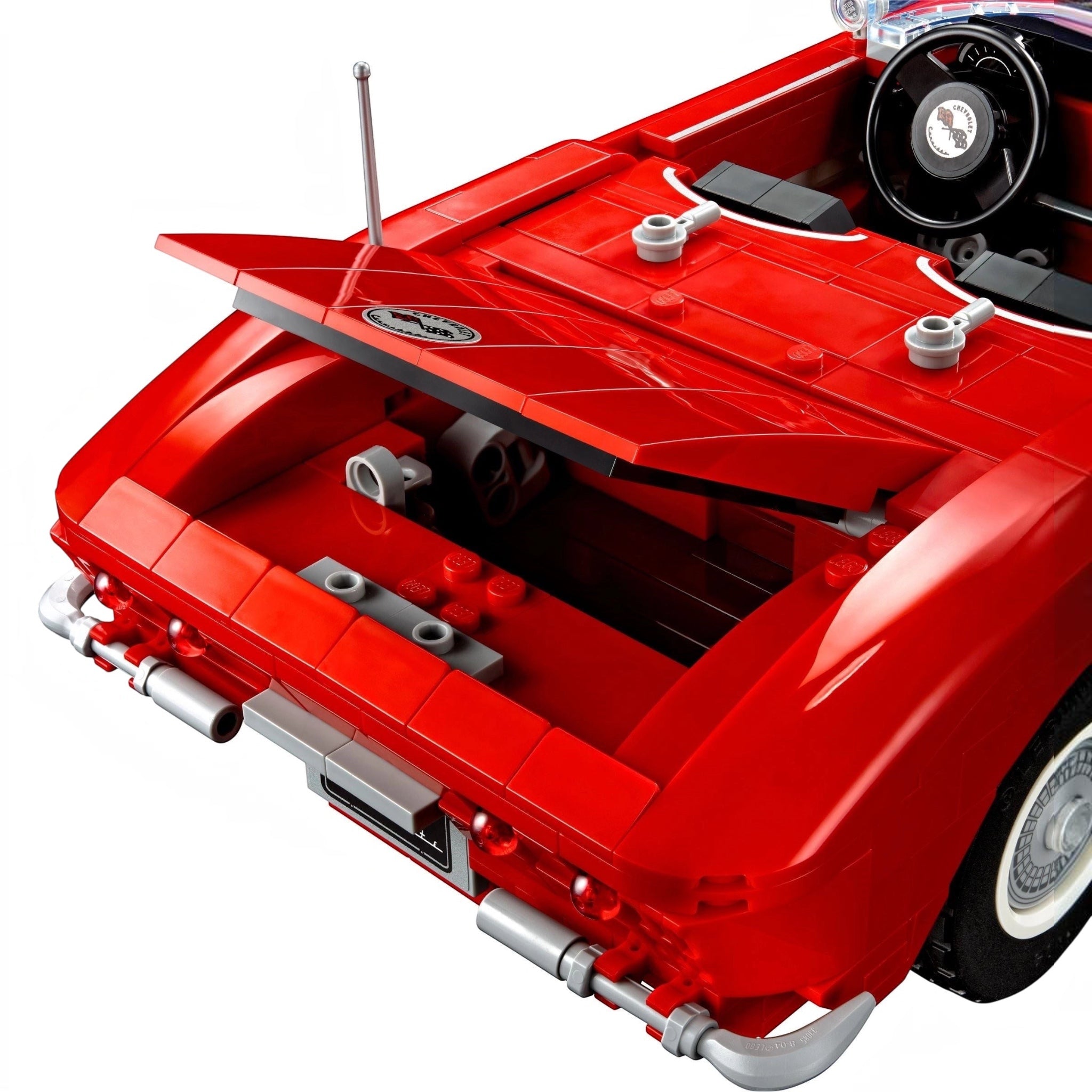 Close-up of a red car model with visible mechanical details on a white background