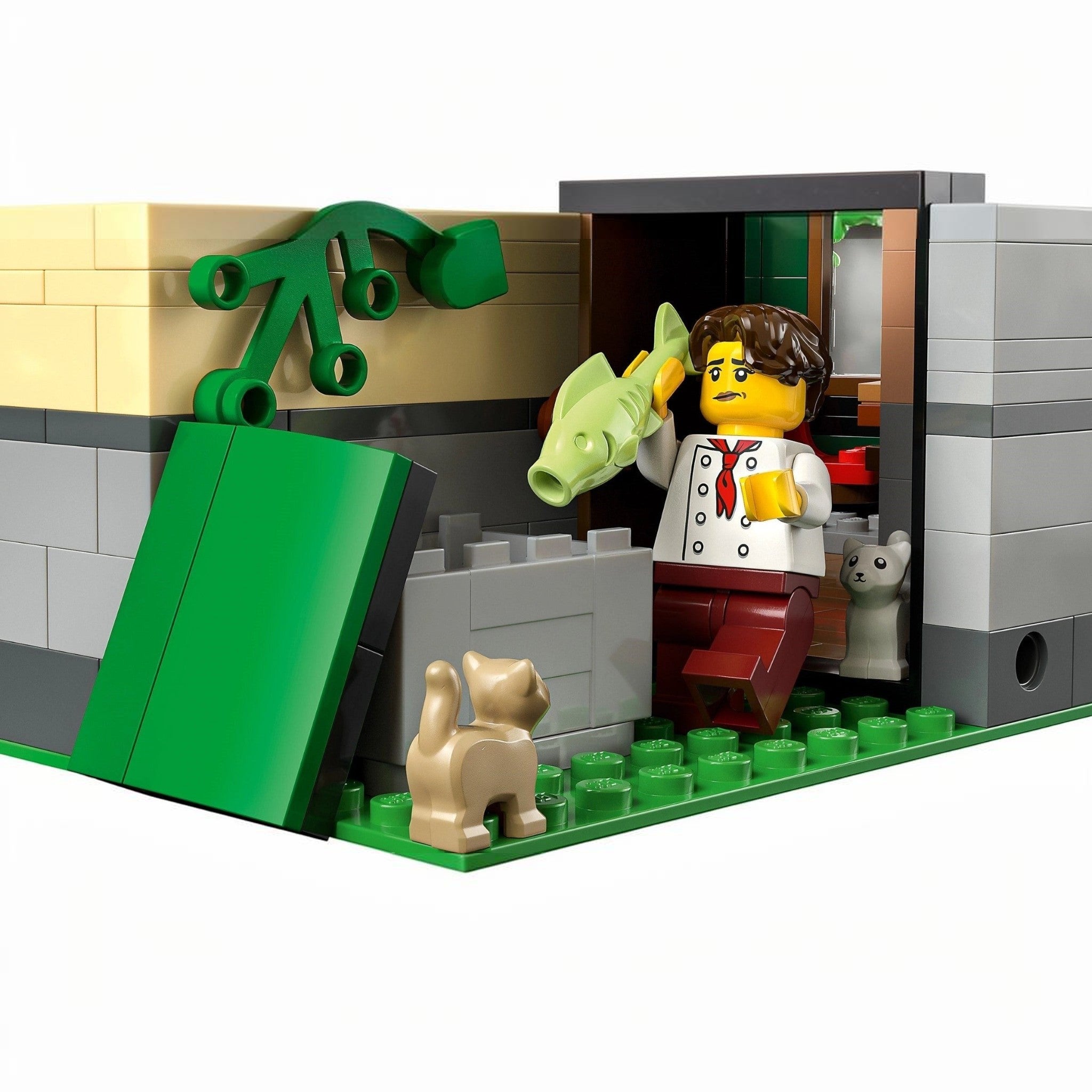 LEGO figure of a person with a dog and a fish, standing next to a green door.