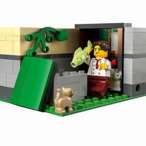 LEGO figure of a person with a dog and a fish, standing next to a green door.