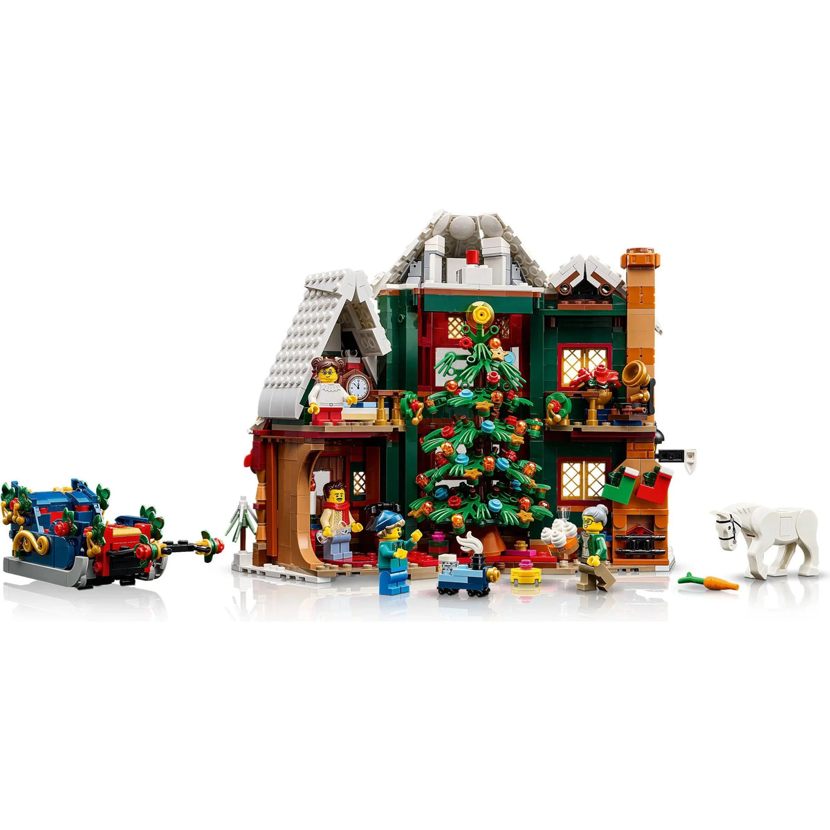 [built-angle] A detailed LEGO Christmas village set featuring a decorated holiday cottage with multiple minifigures, a sleigh, a horse, and a tree, photographed on a clean white background.