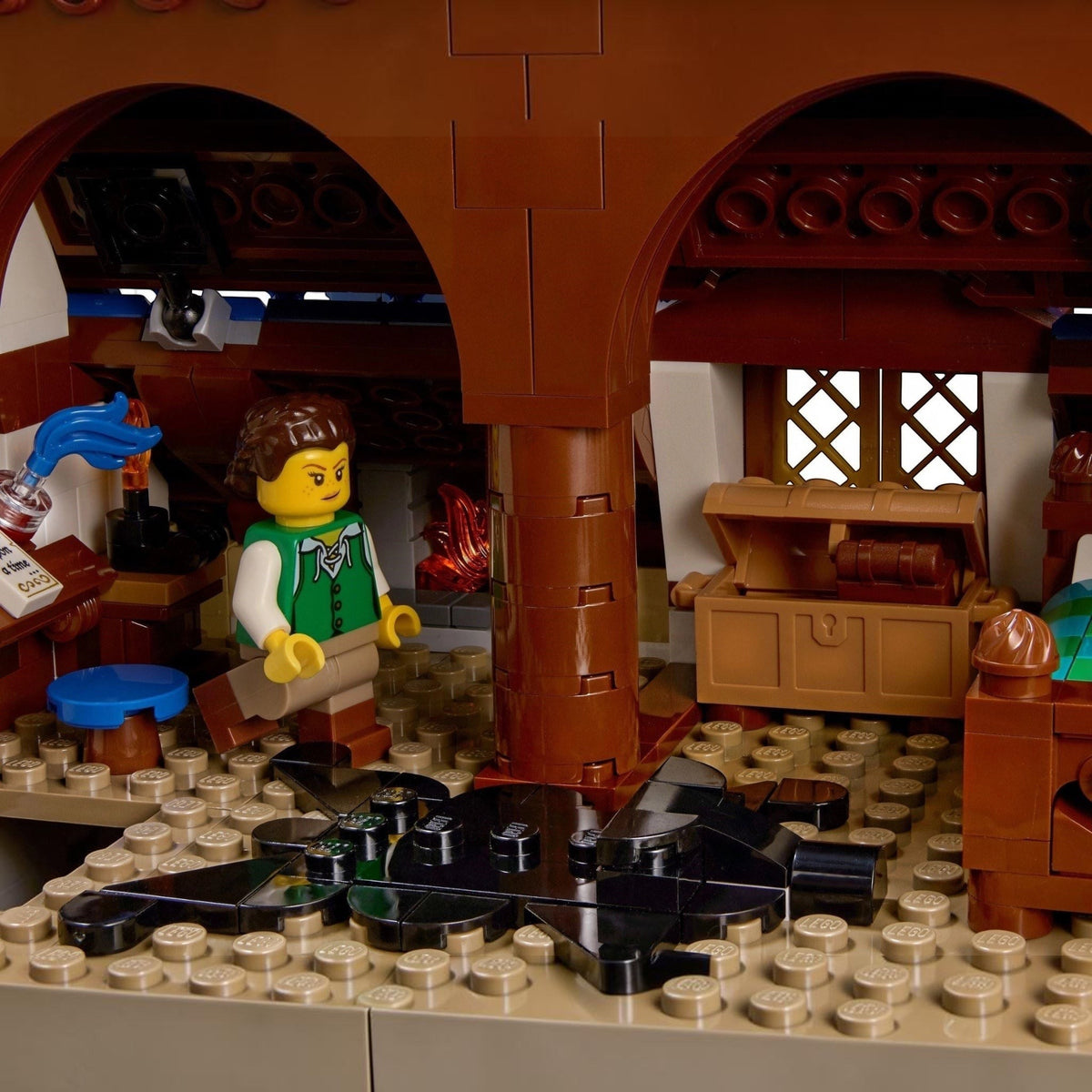 [built-detail] LEGO figure in a rustic interior setting with wooden furniture and a chest.