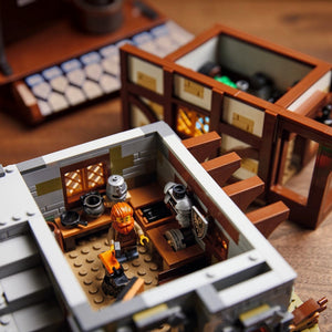 [built-detail] Close-up of a LEGO set with characters and furniture.