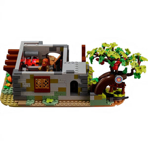 [built-angle] Toy set with a small building, characters, and a tree with green leaves.