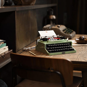 Vintage green typewriter on a wooden desk with a blurred background