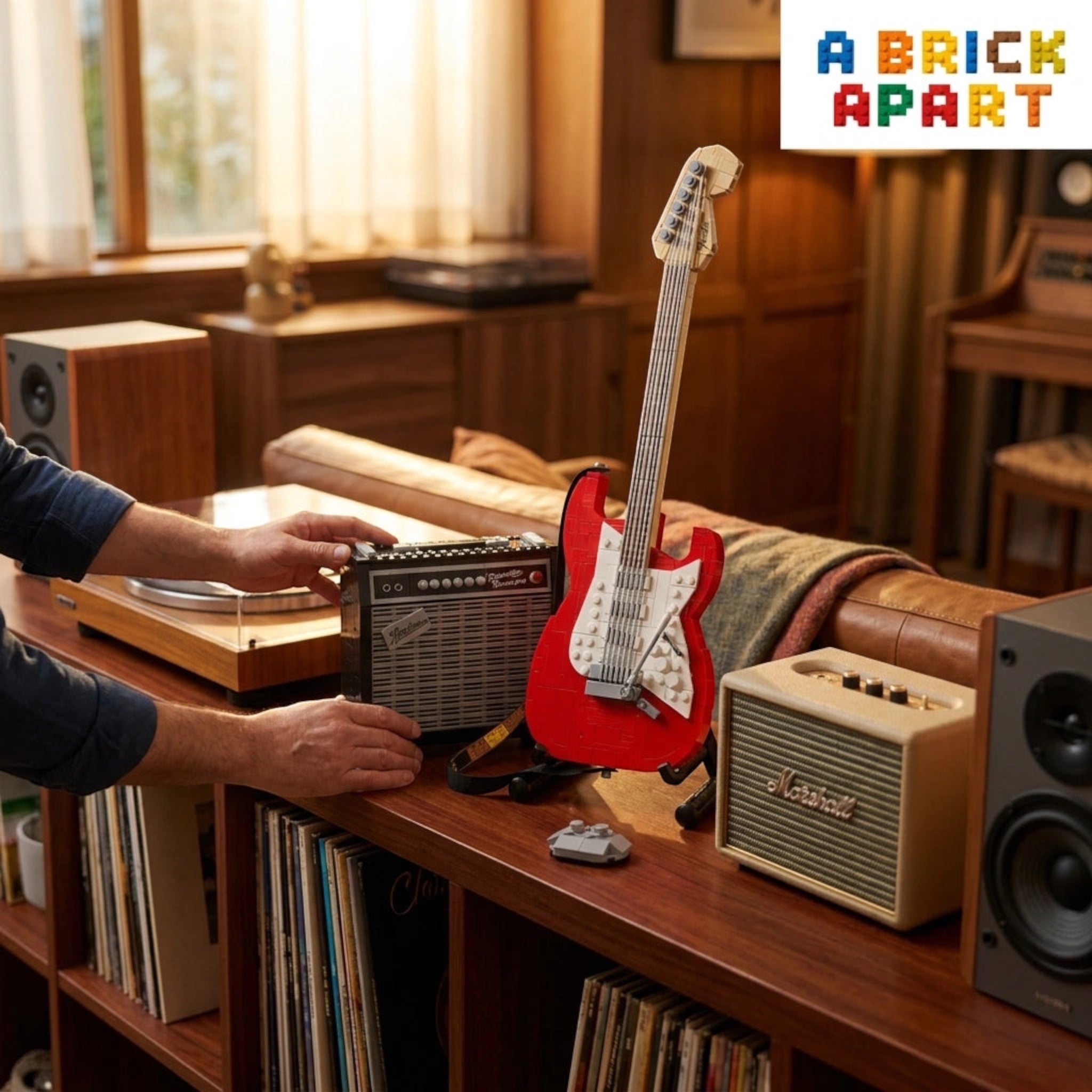 Person interacting with a vintage radio and amplifier on a wooden shelf with a guitar and records.