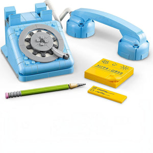 Toy telephone set with rotary dial, handset, pen, and sticky notes on a white background