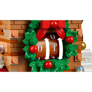[built-detail] Close-up of a LEGO Christmas advent clock showing the number 11, decorated with a green wreath, red bow, and red berries, set against a white background.