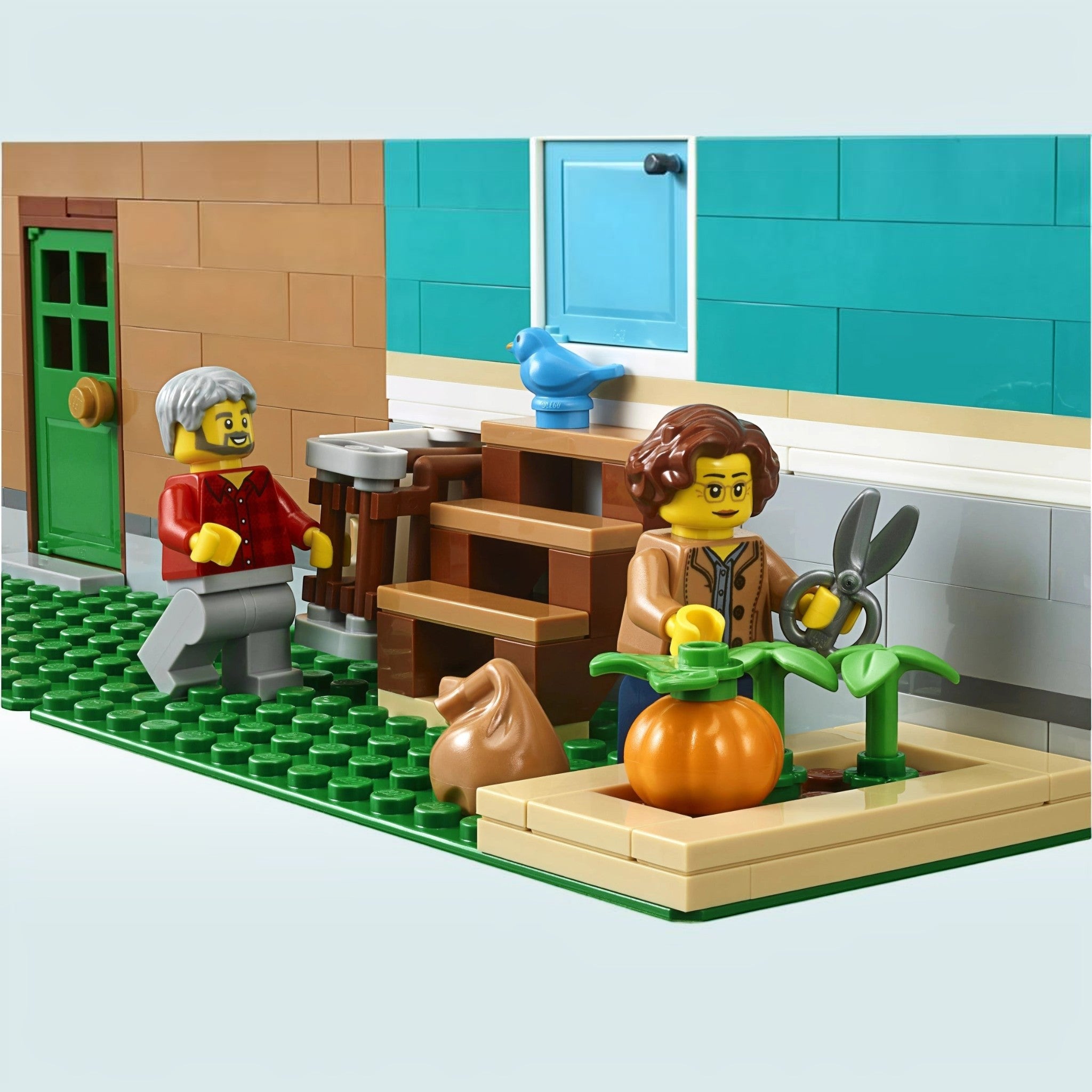 A Brick Apart LEGO Creator Expert Bookshop minifigures gardening with a pumpkin and shears outside the modular building
