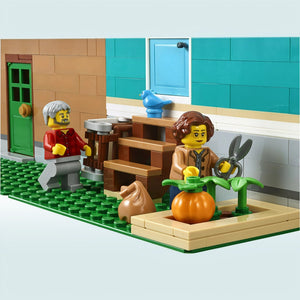 A Brick Apart LEGO Creator Expert Bookshop minifigures gardening with a pumpkin and shears outside the modular building