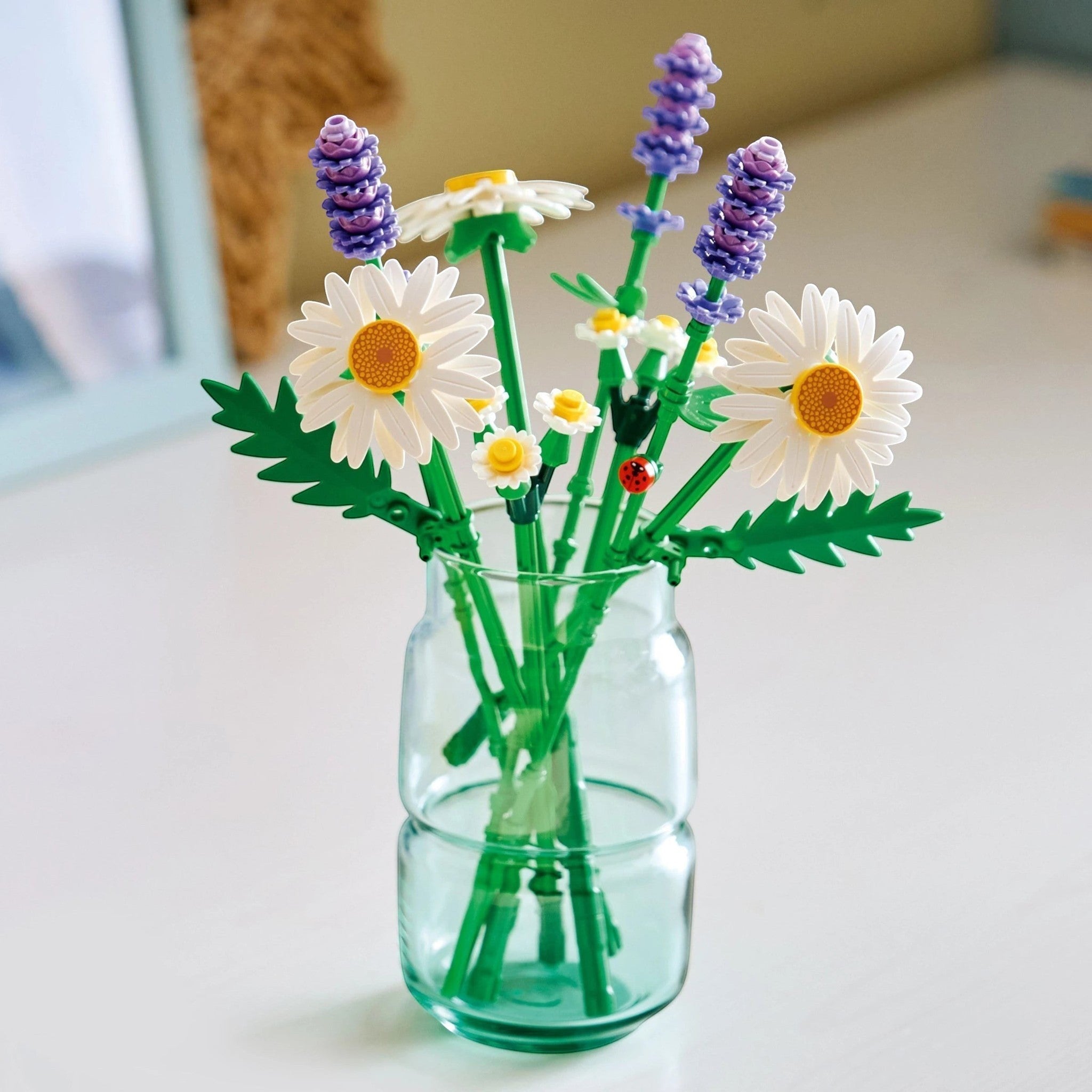 A Brick Apart LEGO Botanicals Daisies set featuring white daisies, purple lavender, and a ladybug in a glass vase.