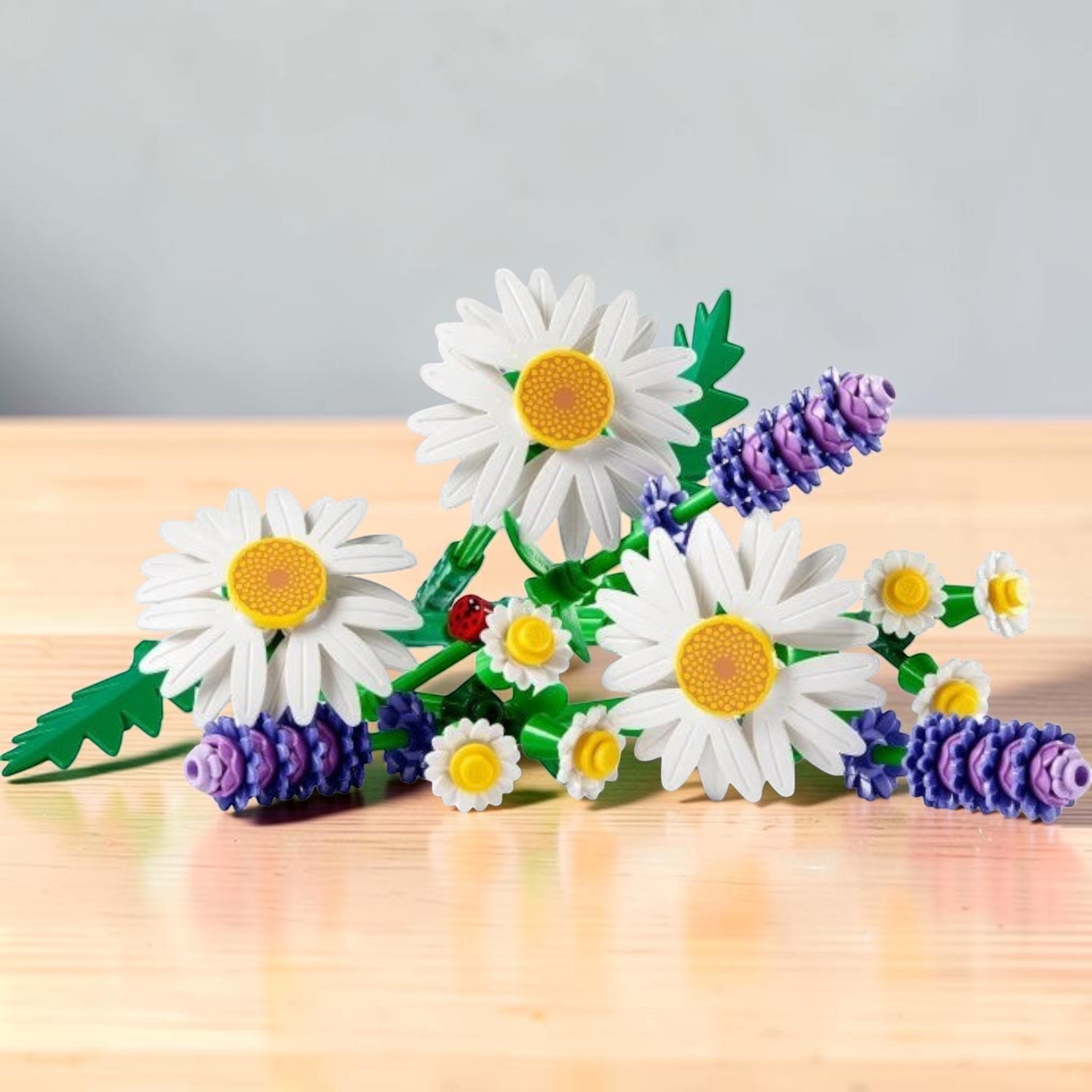 A Brick Apart LEGO Botanicals Daisies set featuring white daisies, purple lavender, green stems, and a tiny ladybug.
