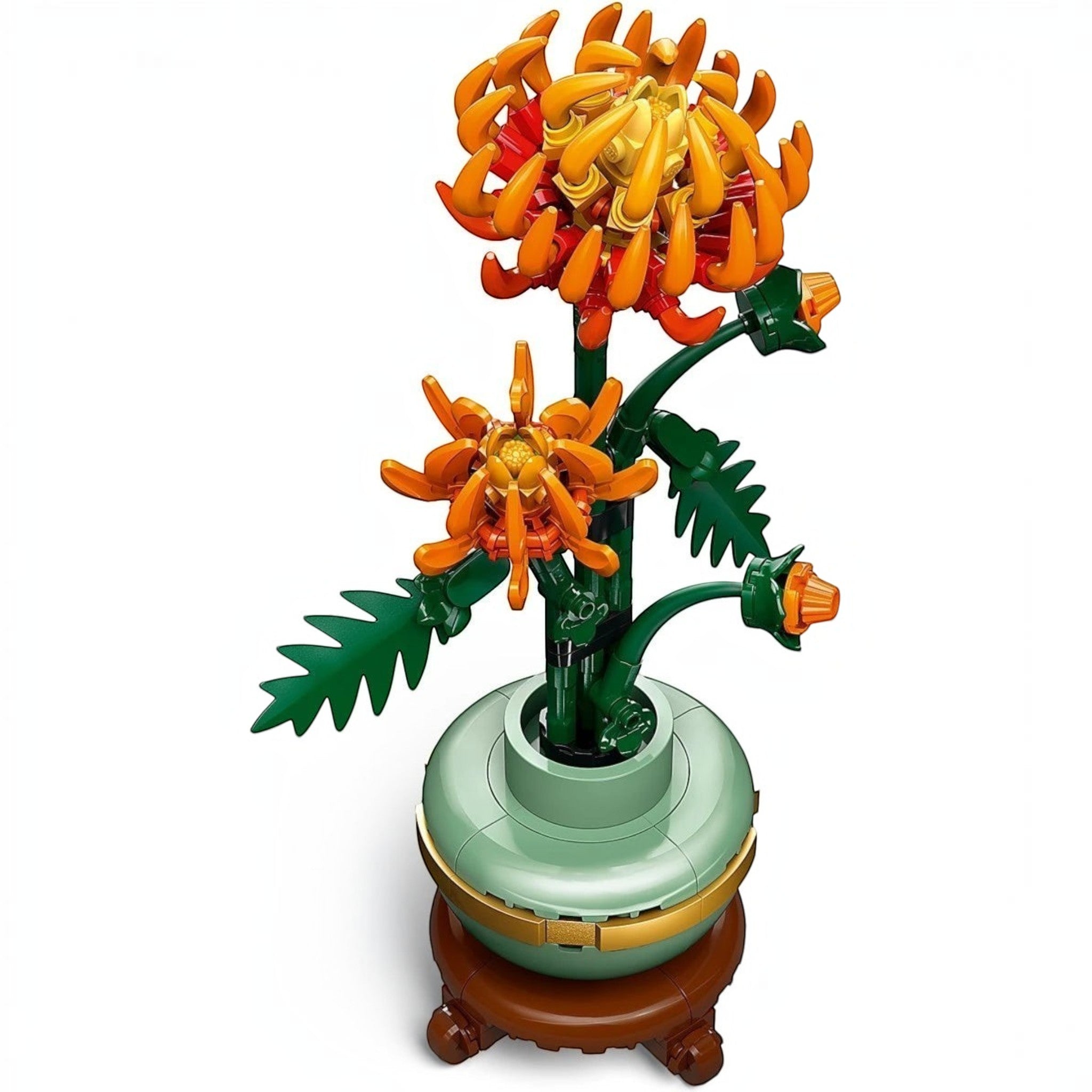 A Brick Apart LEGO Icons Chrysanthemum set featuring vivid orange flowers in a pastel-green pot on a wood-effect plinth.