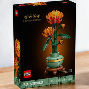 A Brick Apart LEGO Icons Chrysanthemum building set box featuring a vibrant orange flower in a pastel-green pot.