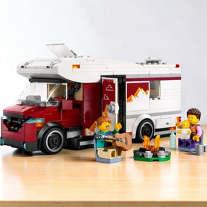 A Brick Apart LEGO City Holiday Camper Van set featuring a red and white vehicle, minifigure family, and campfire.