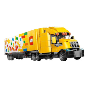 [built-angle] A Brick Apart LEGO City yellow delivery truck with a trailer featuring colorful brick graphics and a minifigure driver.