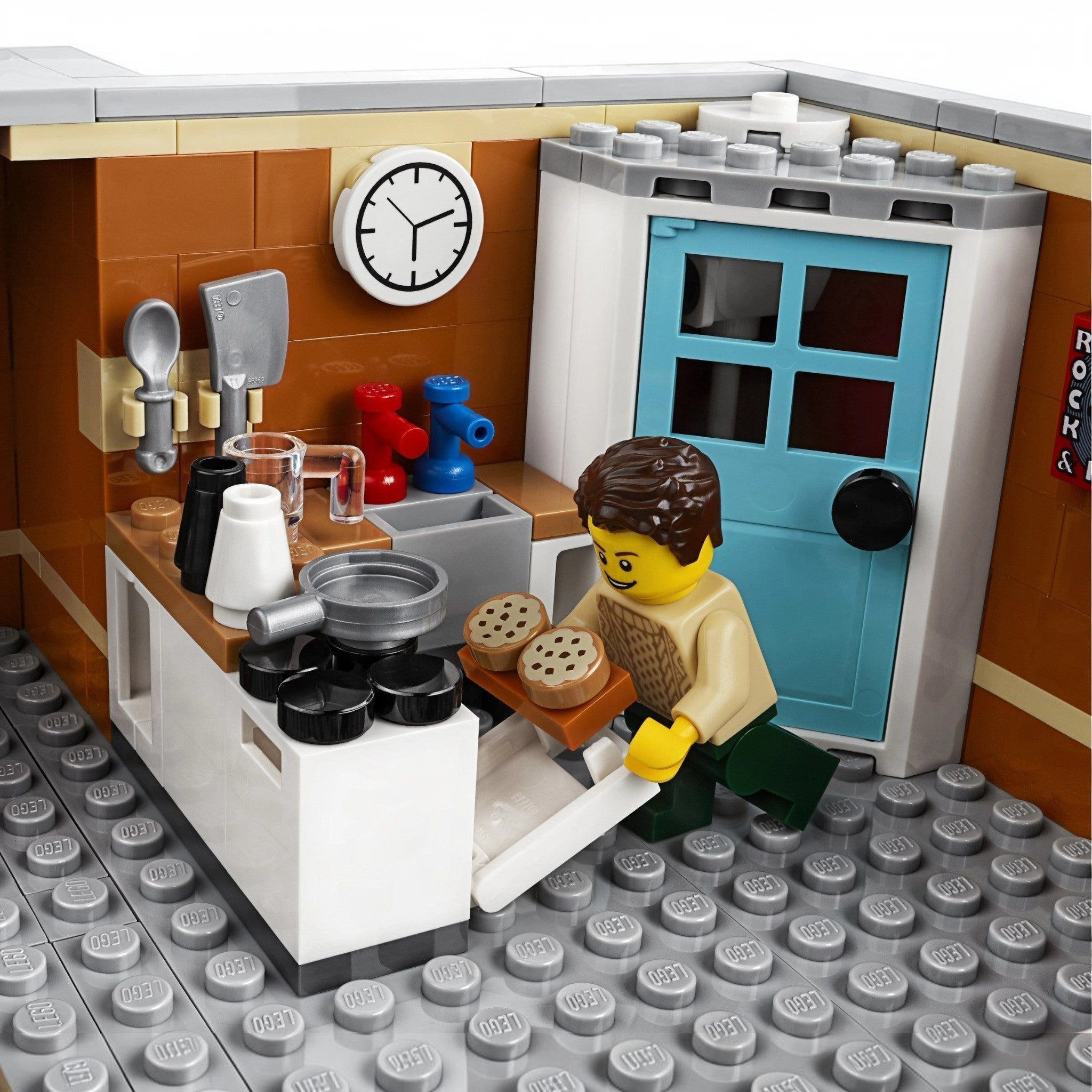 A Brick Apart LEGO Creator Expert Corner Garage apartment kitchen interior with a minifigure baking cookies in an oven.