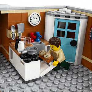A Brick Apart LEGO Creator Expert Corner Garage apartment kitchen interior with a minifigure baking cookies in an oven.