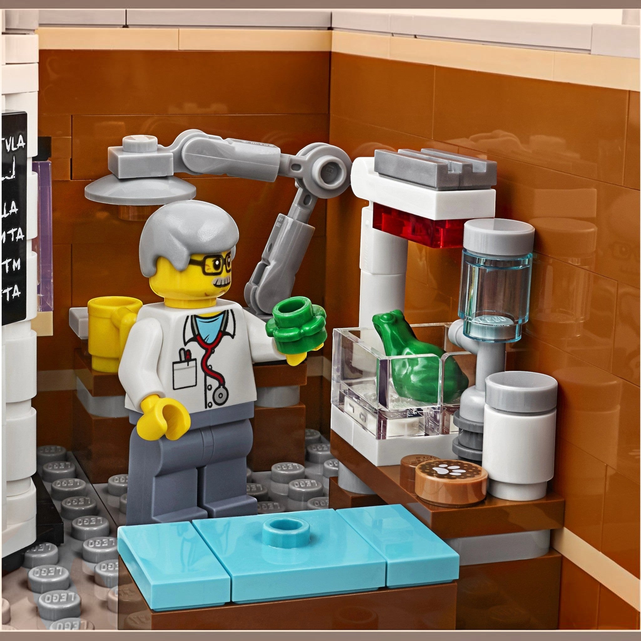 A Brick Apart LEGO Creator Expert Corner Garage vet minifigure examining a green frog in the animal clinic interior.