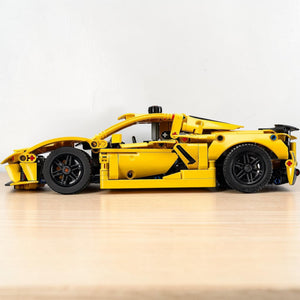 [lifestyle-shelf-built] A Brick Apart LEGO Technic Chevrolet Corvette Stingray model in bright yellow, shown from a side profile view.
