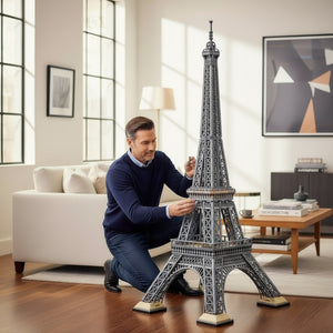 [lifestyle-person] A Brick Apart LEGO Icons Eiffel Tower set being assembled by a man in a bright, modern living room.