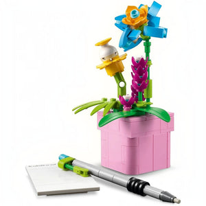 A Brick Apart LEGO Creator 3in1 flowerpot build with colorful brick-built flowers, a grey pen, and a notebook.