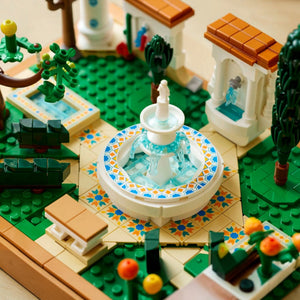 A Brick Apart LEGO Icons Fountain Garden set featuring a central tiered fountain, tiled pathways, and lush greenery.