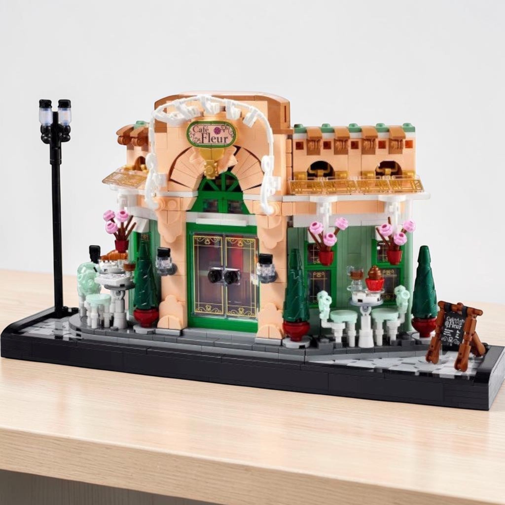 A Brick Apart LEGO Icons French Café building set featuring a detailed bistro facade with flowerpots and streetlamp.