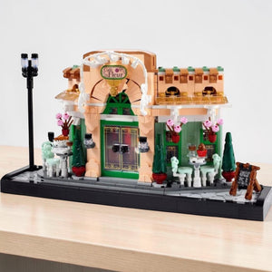 A Brick Apart LEGO Icons French Café building set featuring a detailed bistro facade with flowerpots and streetlamp.