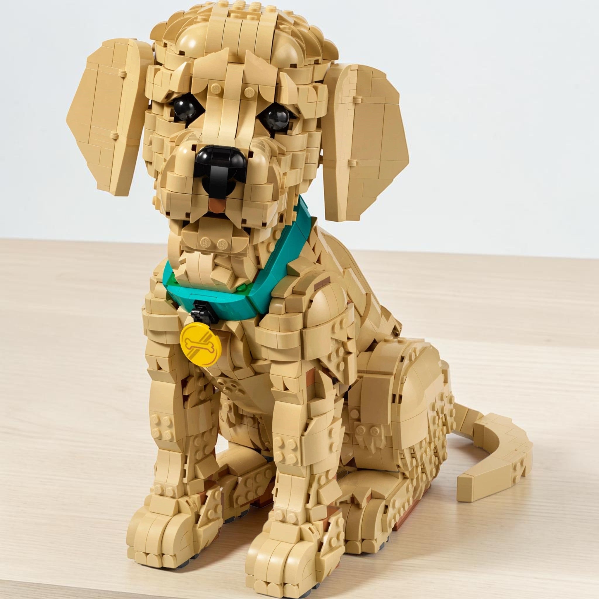 A Brick Apart LEGO Icons Golden Retriever Puppy model featuring a tan dog with a teal collar and yellow medallion.