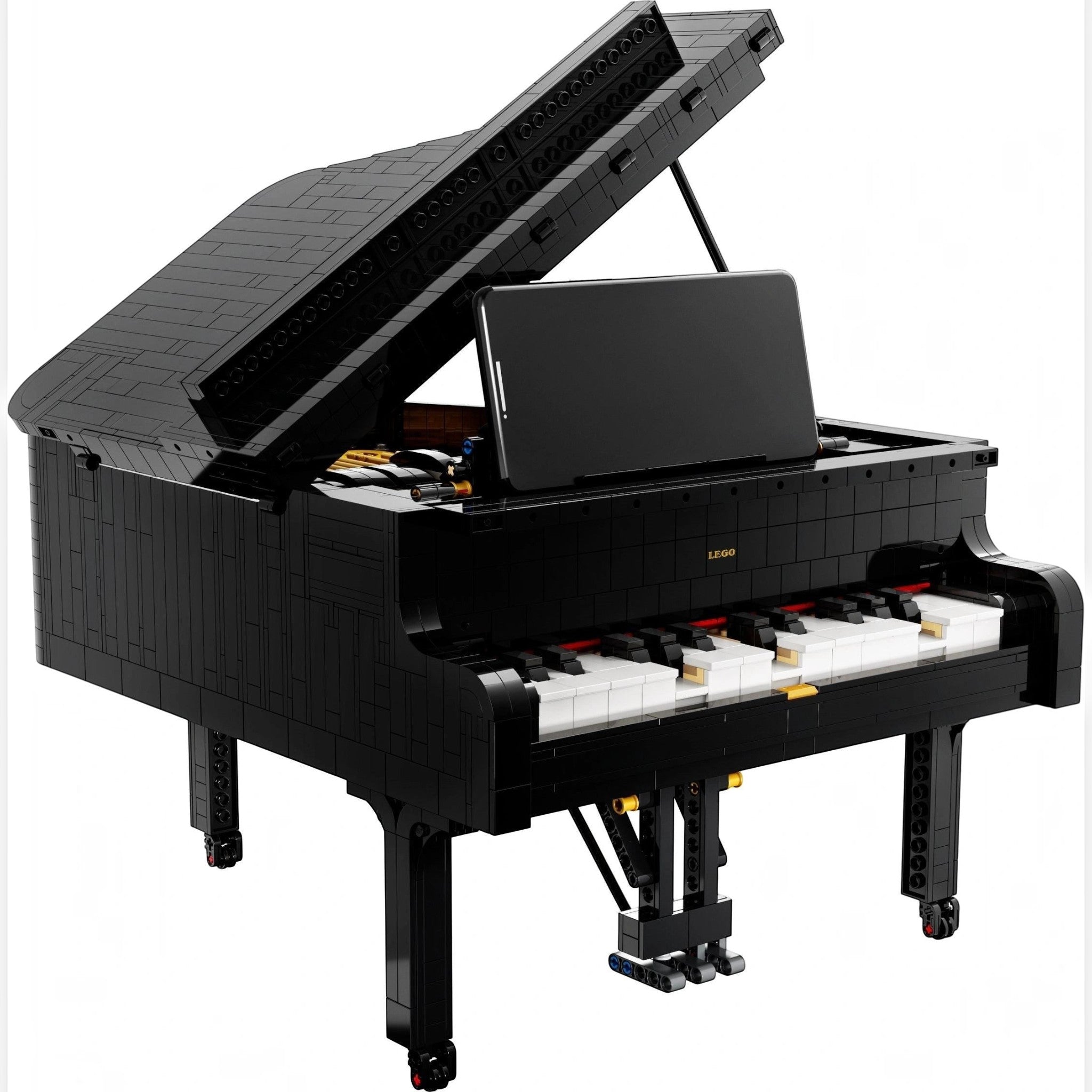 A Brick Apart LEGO Ideas Grand Piano set with a black brick-built body, open lid, and smartphone mounted on the keys.