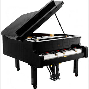 A Brick Apart LEGO Ideas Grand Piano model with black exterior, white keys, and an open lid showing internal details.