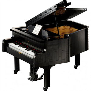 A Brick Apart LEGO Ideas Grand Piano model with black casing, white keys, and an open lid showing internal details.