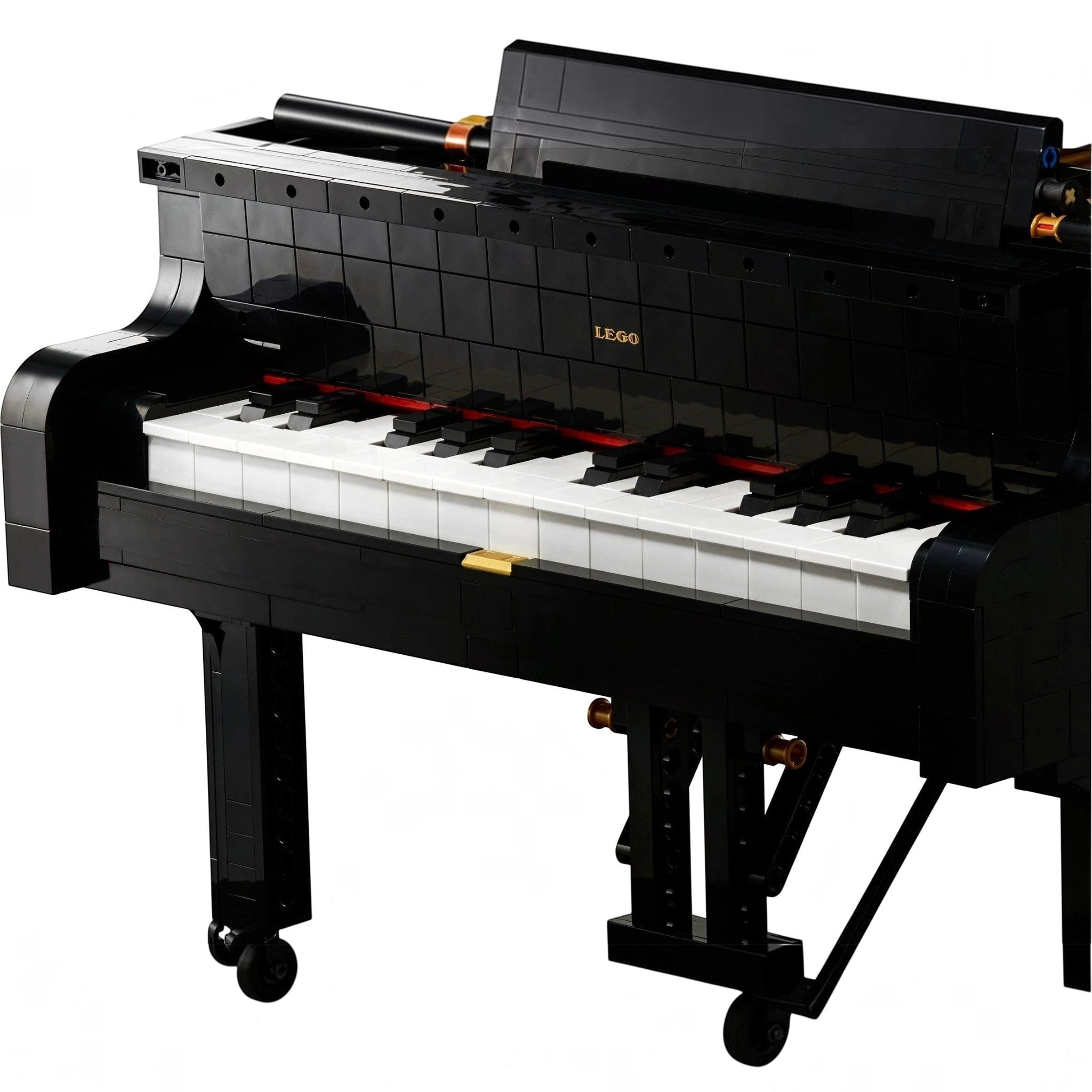 A Brick Apart LEGO Ideas Grand Piano model with black casing, white keys, and authentic moving hammer action mechanism.