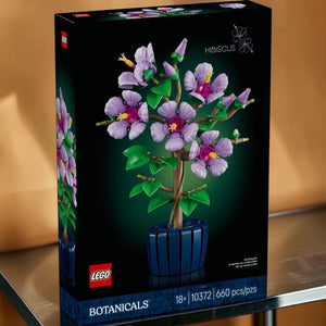 A Brick Apart LEGO Botanicals Hibiscus set box featuring a brick-built lavender flower plant in a dark blue pot.