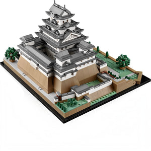 A Brick Apart LEGO Architecture Himeji Castle model featuring grey and white turrets, stone walls, and cherry trees.