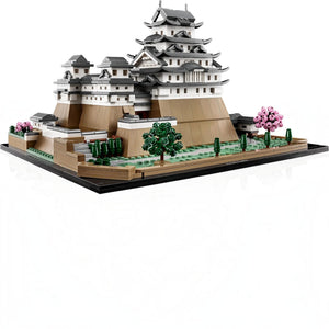 A Brick Apart LEGO Architecture Himeji Castle model featuring white towers, tan walls, and pink cherry blossom trees.