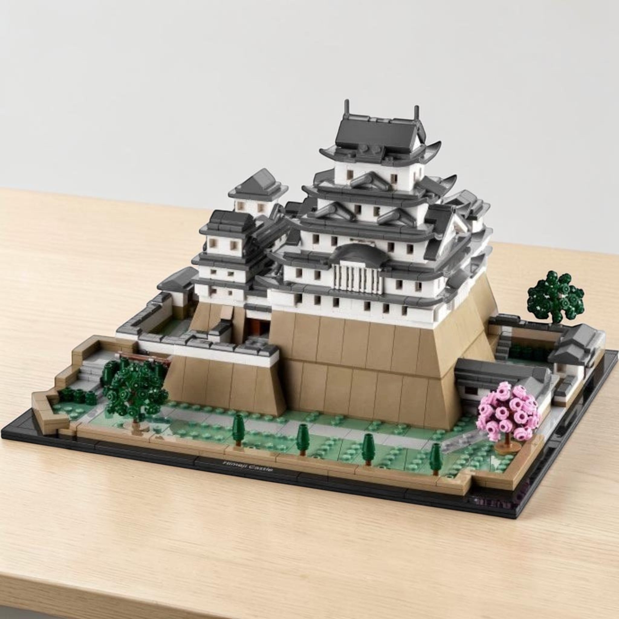 A Brick Apart LEGO Architecture Himeji Castle model featuring white and grey castle walls with pink cherry trees.
