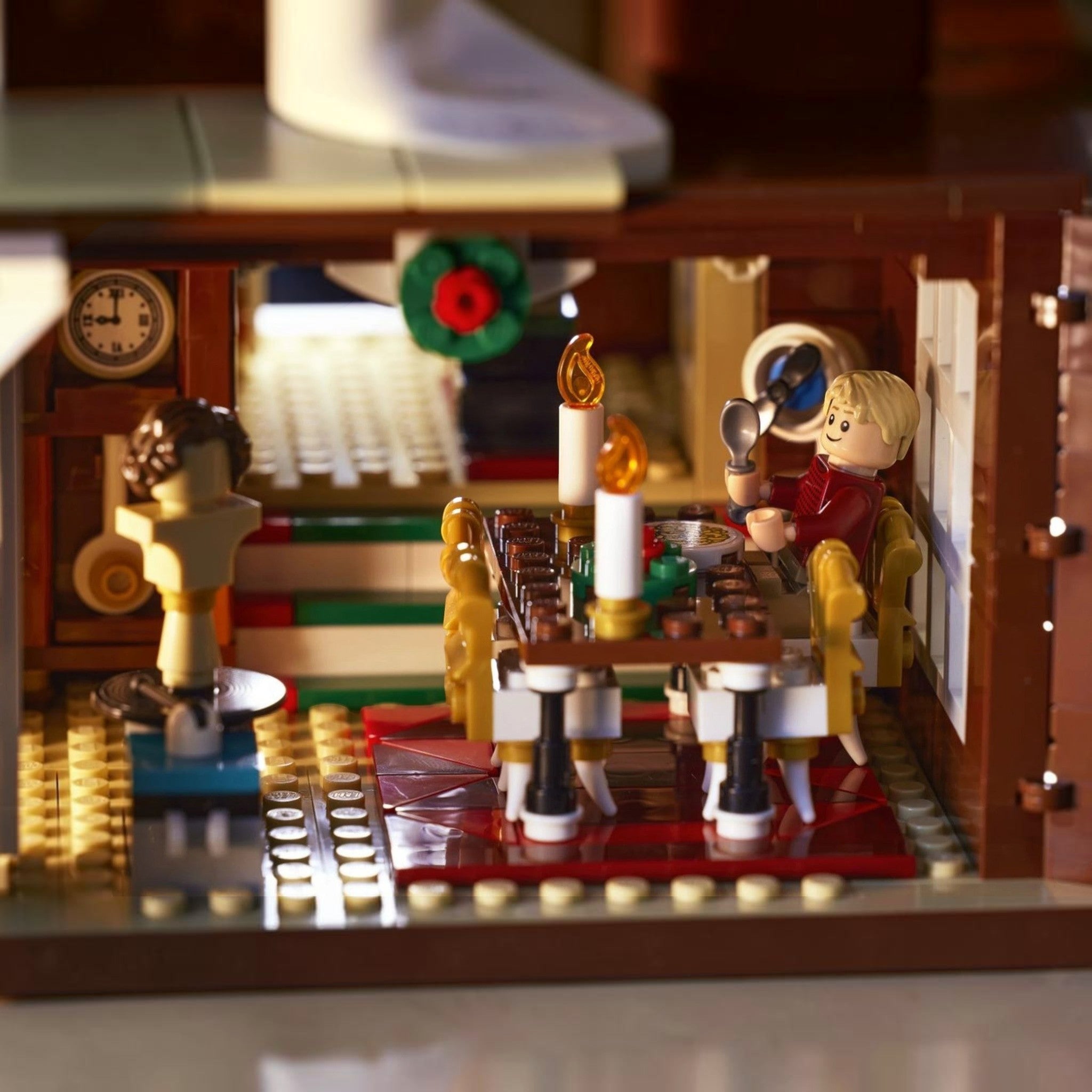 A Brick Apart LEGO Home Alone set interior showing Kevin McCallister at a dining table with candles and a mannequin